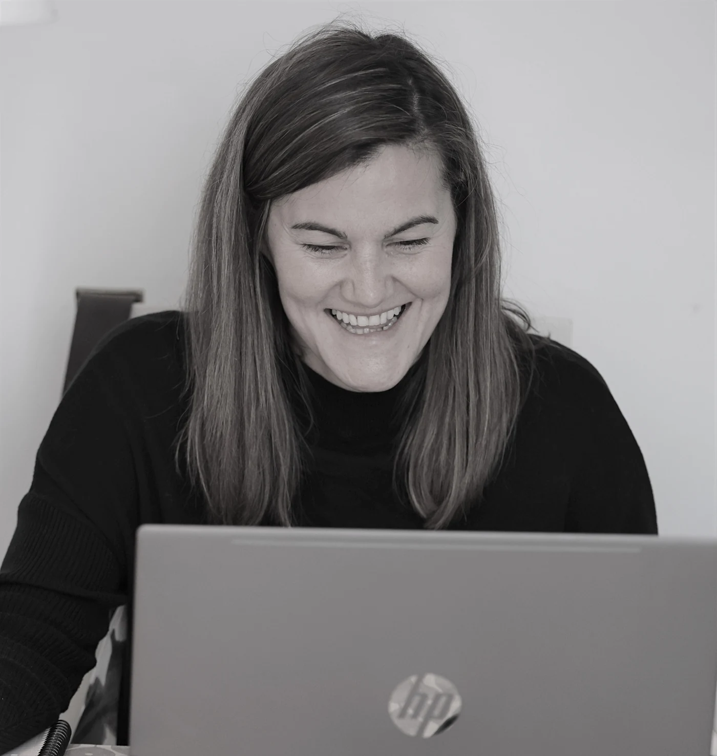 Katie O'Hare working, laughing at her laptop